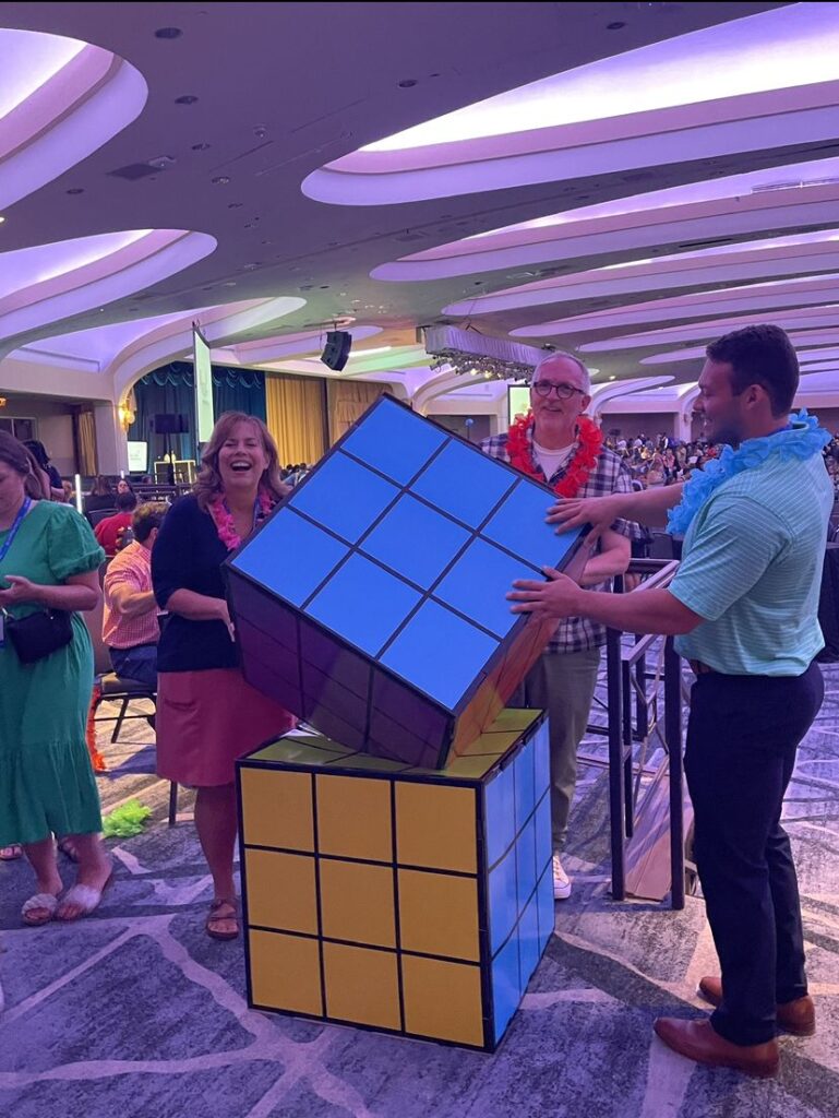 Staff posing with a giant Rubik's Cube